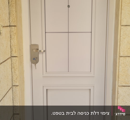 דלת לבנה עם ידית מתכת ומנעול